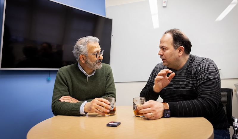 Nader Engheta and Firooz Aflatouni chat over mugs of tea the latter's office. 