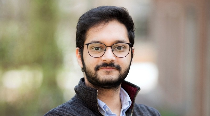 A portrait of Nandan Tumu wearing glasses and a collared shirt.