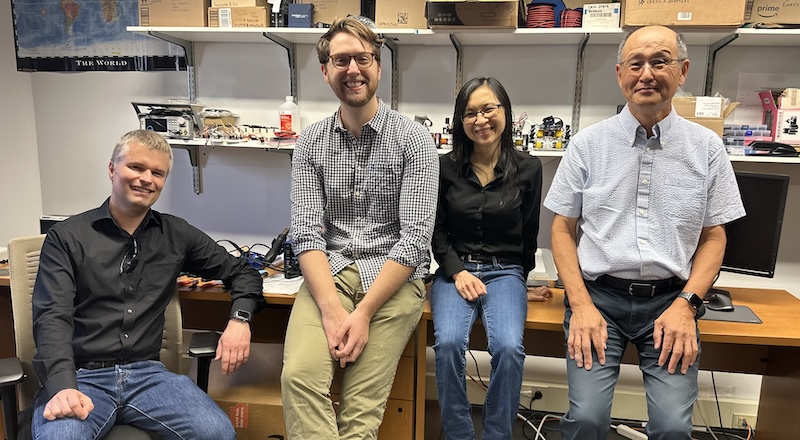 Four researchers sit side by side in a lab. 